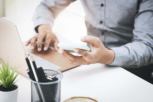 Business men are using their mobile phones to connect with their partners to talk about adjusting their profitable strategies.