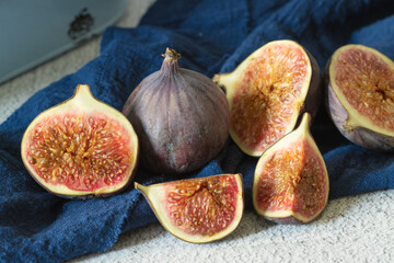 whole and cut figs on a blue towel
