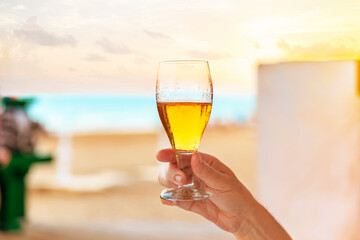 close up of a hand with a refreshing glass of beer