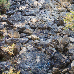 A rockfall in the mountains. Rocks of various sizes blocked a na