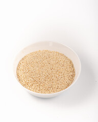 White sesame seeds in a white plate isolated on a white background. High quality photo
