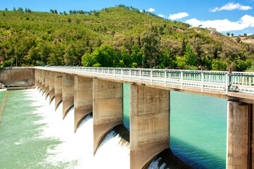 Dam of a mountain river in Turkey. Water release in the mountains on a sunny day
