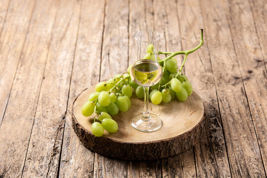Italian golden grappa drink on wooden table