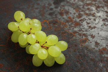 Green bunch of grapes on a metallic background with rust