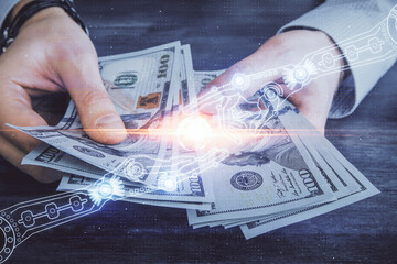 Multi exposure of technology drawing hologram and us dollars bills and man hands. Data concept