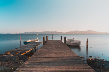 Fototapeta premium Long exposure view of a little pier and little fisherman's boats at Giliacquas park at sunset