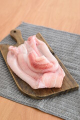 some hake fillets on a wooden board on the table