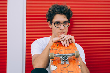 young man posing with his skateboard © cherryandbees