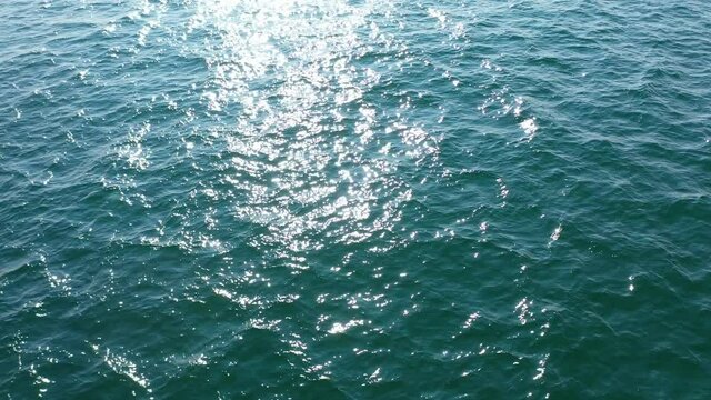 Top View Slow motion looping c ripples and wave, Refraction of sunlight top view texture sea side, Foaming and Splashing in the Ocean, Sunny Day, Slow Motion Video. Veiw from drone