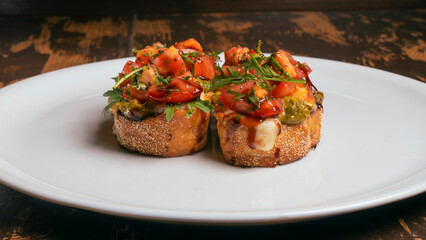 Close-up view of tomato and mozzarella bruschetta on white plate on red brick wall background. Healthy life concept.