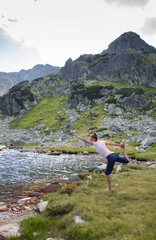 Naklejka na ściany i meble healthy young woman doing yoga in mountain landscape by lake
