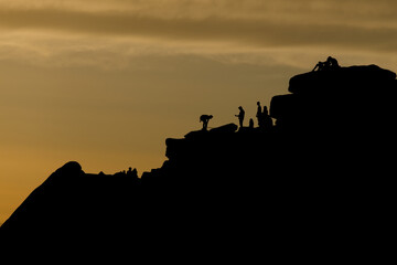 Dusky sunset peak district scene. People line the top of stanage edge