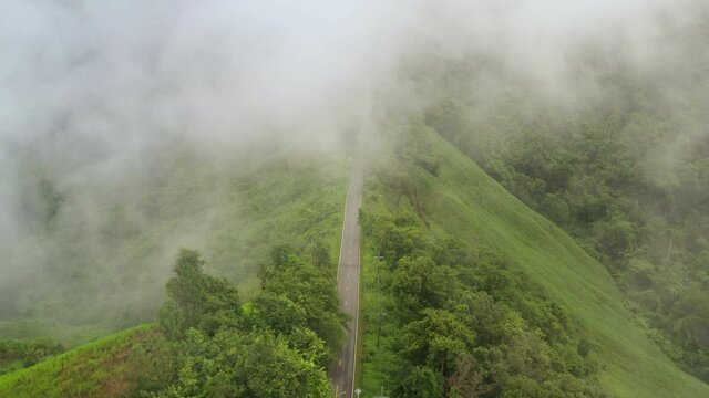 Aerial view of countryside road passing through the lush greenery and foliage tropical rain forest mountain landscape in the Northern Thailand, Nan province. Doi phuka