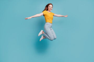 Portrait of careless dreamy inspired lady jump plane posing on blue background