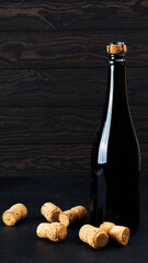 Wine bottle on wood floor and grunge background, nearby cork, tinsel, the concept of the celebration, Christmas