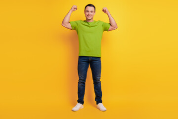 Fototapeta na wymiar Portrait of strong cool guy show two hands muscle on yellow background