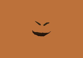 Scary pumpkin face on orange background. Black and orange color. Evil look. Creepy smile. Flat lay.