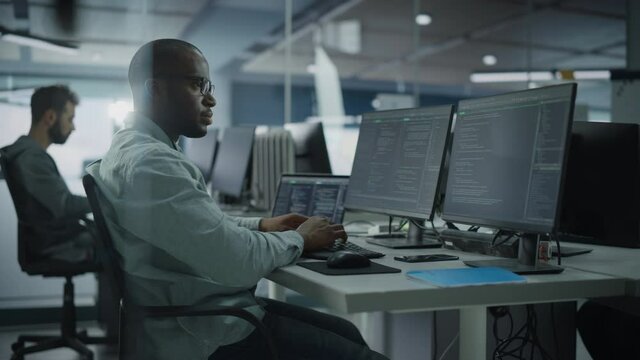 Authentic Office: Professional Black IT Programmer Working on Desktop Computer. Male Website Developer and Software Engineer Developing App, Video Game. Terminal with Coding Programming Language
