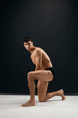 Fototapeta premium sexy man in black panties with a pumped-up body dark background