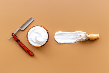 Brush foam shaver and shaving foam in wooden bowl, top view