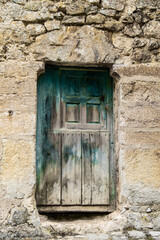 very old green door in stone house