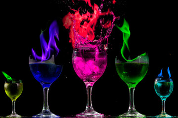 Taças contendo liquido colorido em chamas. Fogo em liquido inflamável. 