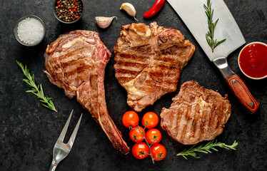 Variety of grilled beef steaks. Ribeye steak, tomahawk, T-bone, on a stone background