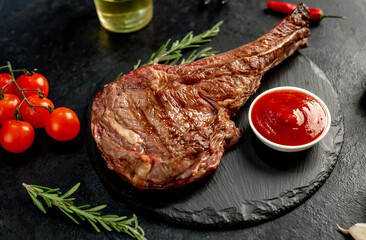 grilled Tomahawk steak with spices on a stone background