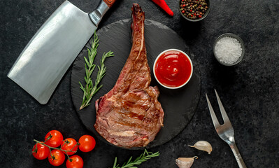 grilled Tomahawk steak with spices on a stone background