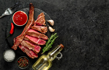 grilled Tomahawk steak with spices on a stone background with copy space for your text