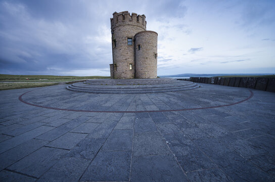 Shot of the O'Brien's Tower on the cliffs of Moher in Ireland under a cloudy blue sky.