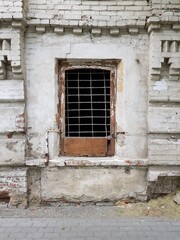 Fototapeta na wymiar An old barred window in the brick wall