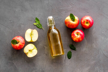 Apple cider vinegar in glass bottle with fresh red apples