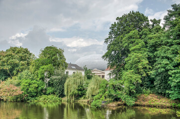 Zwolle, The Netherlands, August 20, 2021: th green banks of the canal surrounding the old town, with the extension of De Fundatie museum almost disappearing against the sky
