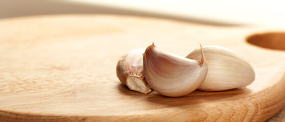 garlic cloves on a wooden cutting board