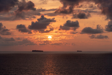 Naklejka na ściany i meble Mystical and inspirational beautiful sunset cloudy sky, over the calm ocean.