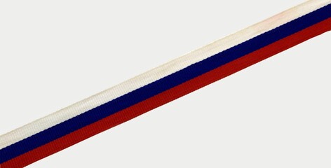 Tricolor on a gray background. Red, blue, white. Tape from the corner