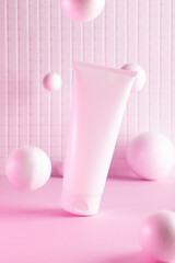 Flying cream bottle with flying balls in a pink neon light, mock up