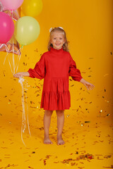 beautiful happy blonde girl in a red dress and balls in farts holiday birthday