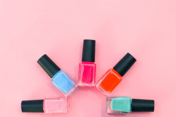 Obraz premium multicolored nail polishes on a pink background.