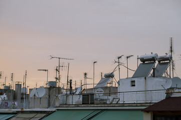 Cityscape of residential area in Athens at evening twilights. Urban architecture. Solar panels and satellite dishes on the roof.
