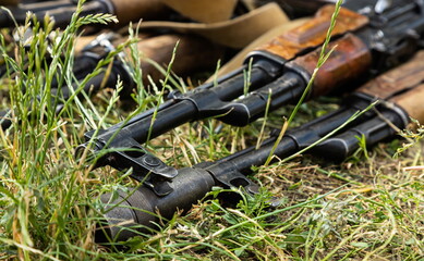 Military machine gun lies on the dry grass in the field