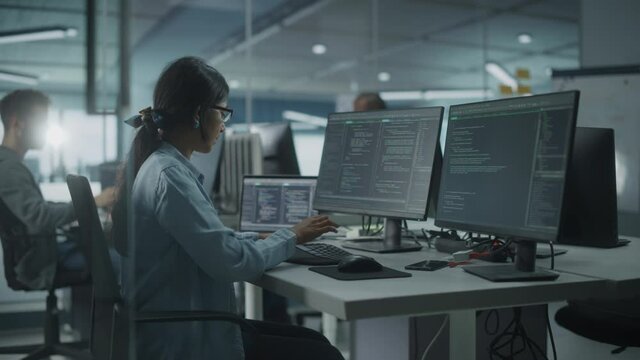 Diverse Office: Indian IT Programmer Working on Desktop Computer. Female Specialist Creating Innovative Software Engineer Developing App, Program, Video Game. Terminal with Coding Language. Arc Shot