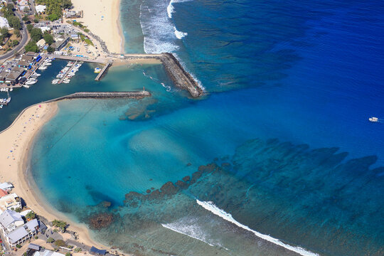 Cristalline blue lagoon waters of West Reunion island and white sand beach