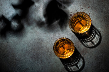 American bourbon whiskey in glasses, black background with shadow pattern and negative space