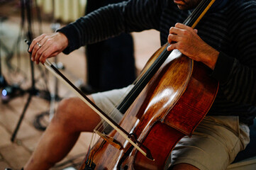 Cellist spielt Musik auf einem Cello mit Bogen. Geringe Schärfentiefe und selektive Schärfe
