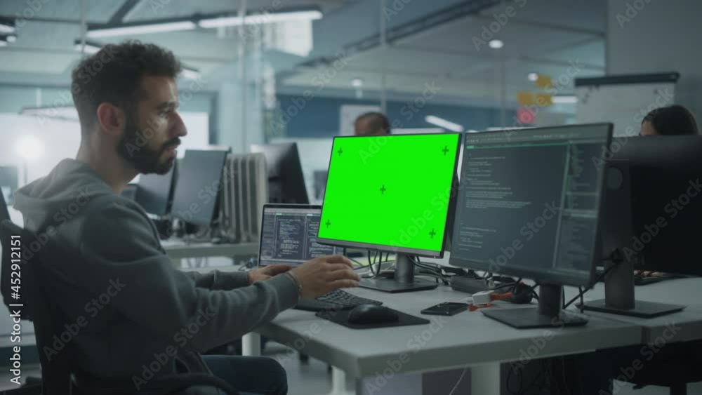 Fototapete multi-ethnic office: white it programmer working on computer with green screen chroma key display. m