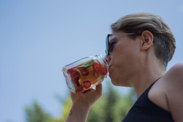 young woman enjoy detox drinks after doing pilates or yoga in their garden.. Selective Focus