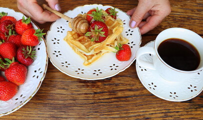 Belgian waffles with fresh berries strawberry , honey and cappuccino coffee for breakfast