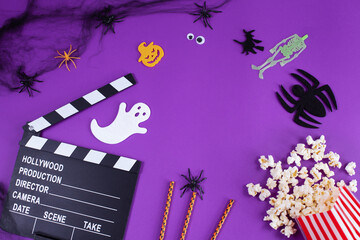 Movie Clapper board in spider webs, spiders, ghost, eyes on purple Lilac Background.